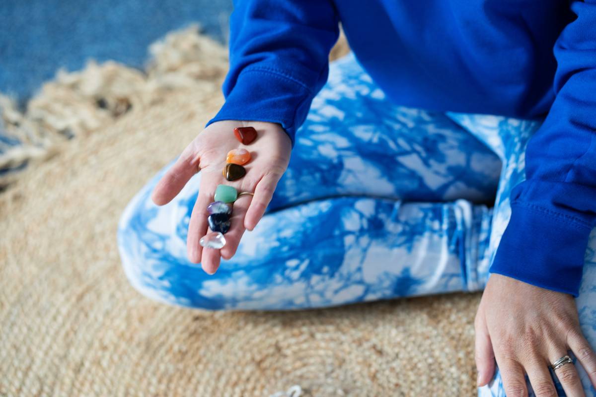 spiritual crystals and stones arranged on a linen cloth with a skincare roller and glass of water