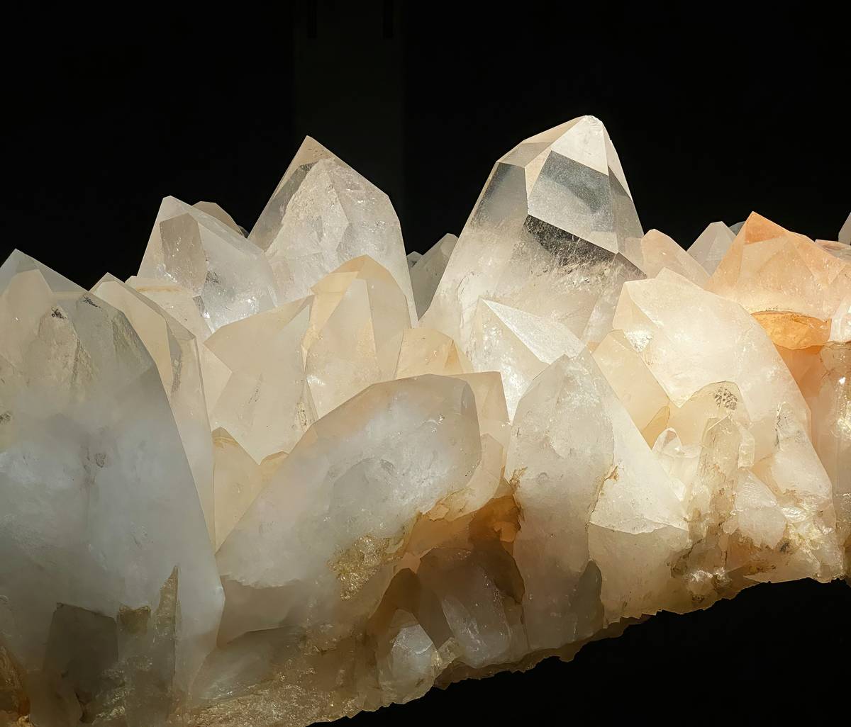 Collection of list of enhanceable spiritual crystals including amethyst clusters, clear quartz points, and selenite wands arranged on linen cloth
